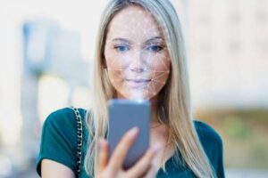 Eine junge Frau nutzt Gesichtserkennung auf ihrem Smartphone zur Verifizierung ihres Profils bei einer Dating-App.