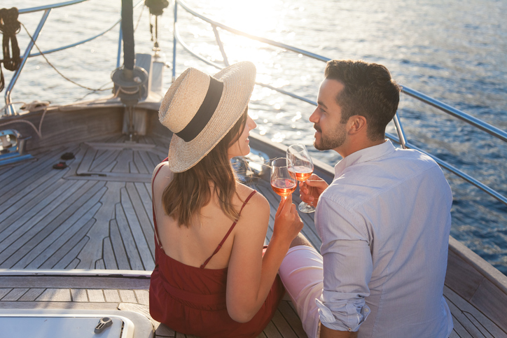 Paar genießt ein romantisches erstes Date auf einem Boot bei Sonnenuntergang.