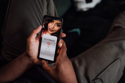 Person hält Smartphone mit einer Dating-App in der Hand, auf dem „It’s a Match!“ angezeigt wird.