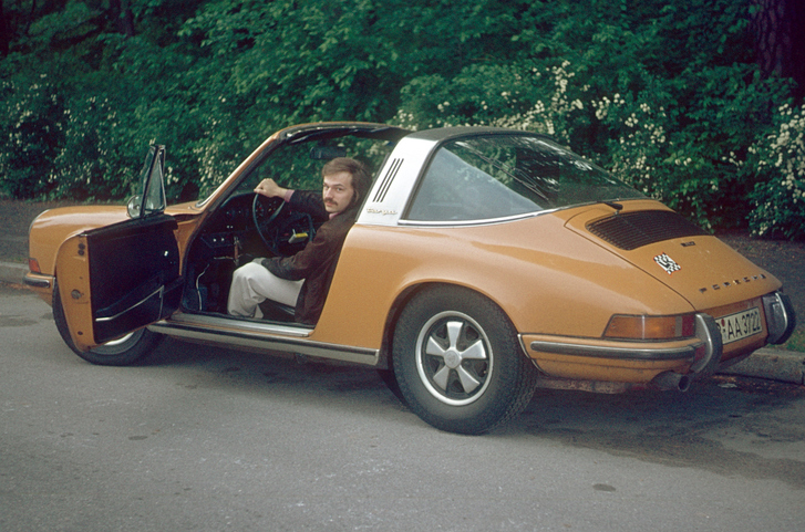 Mann sitzt in einem klassischen Porsche – Statussymbole im Dating mit Geschichte